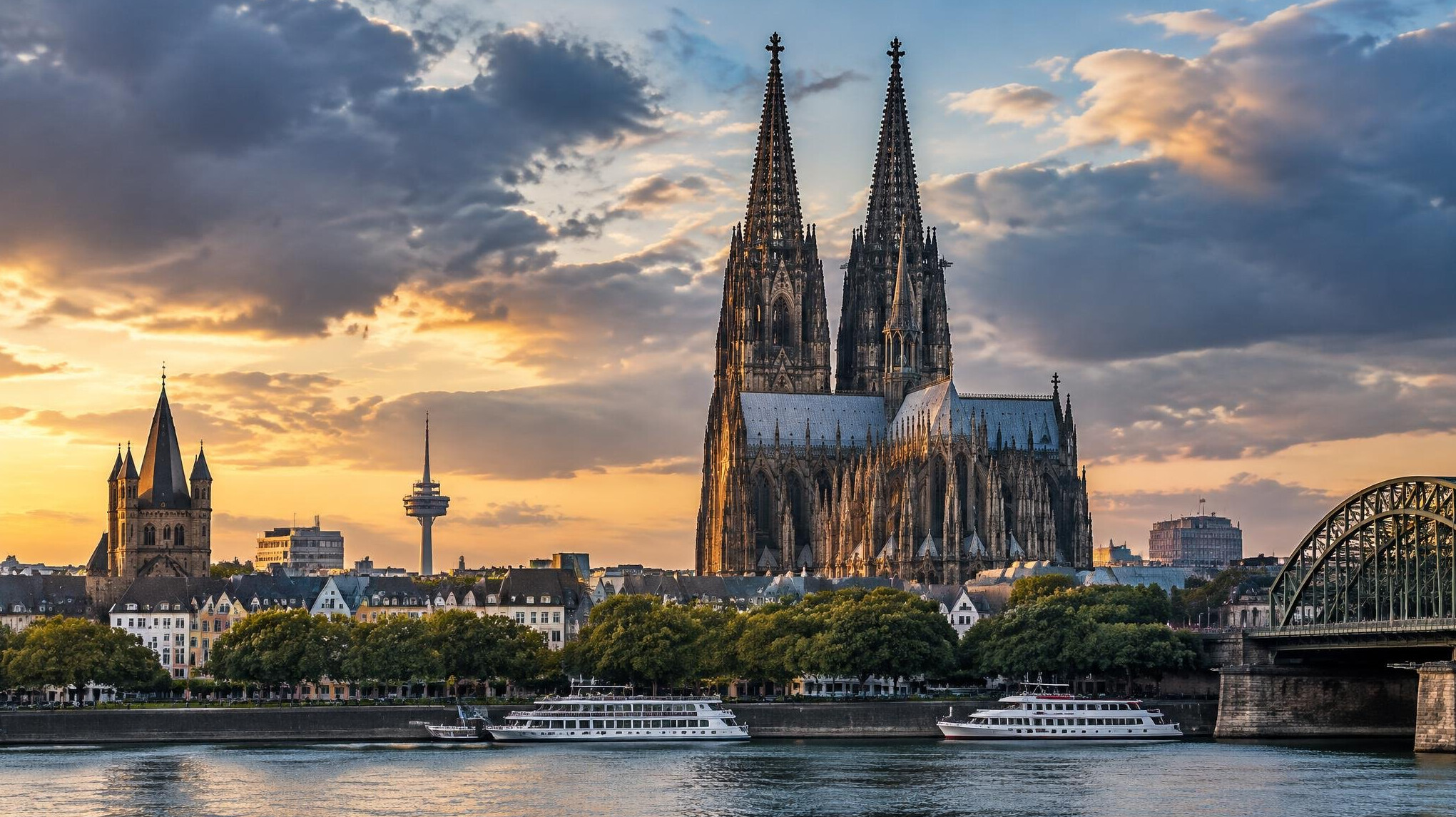 Zwei gotische Kirchtürme ragen über eine Stadt empor