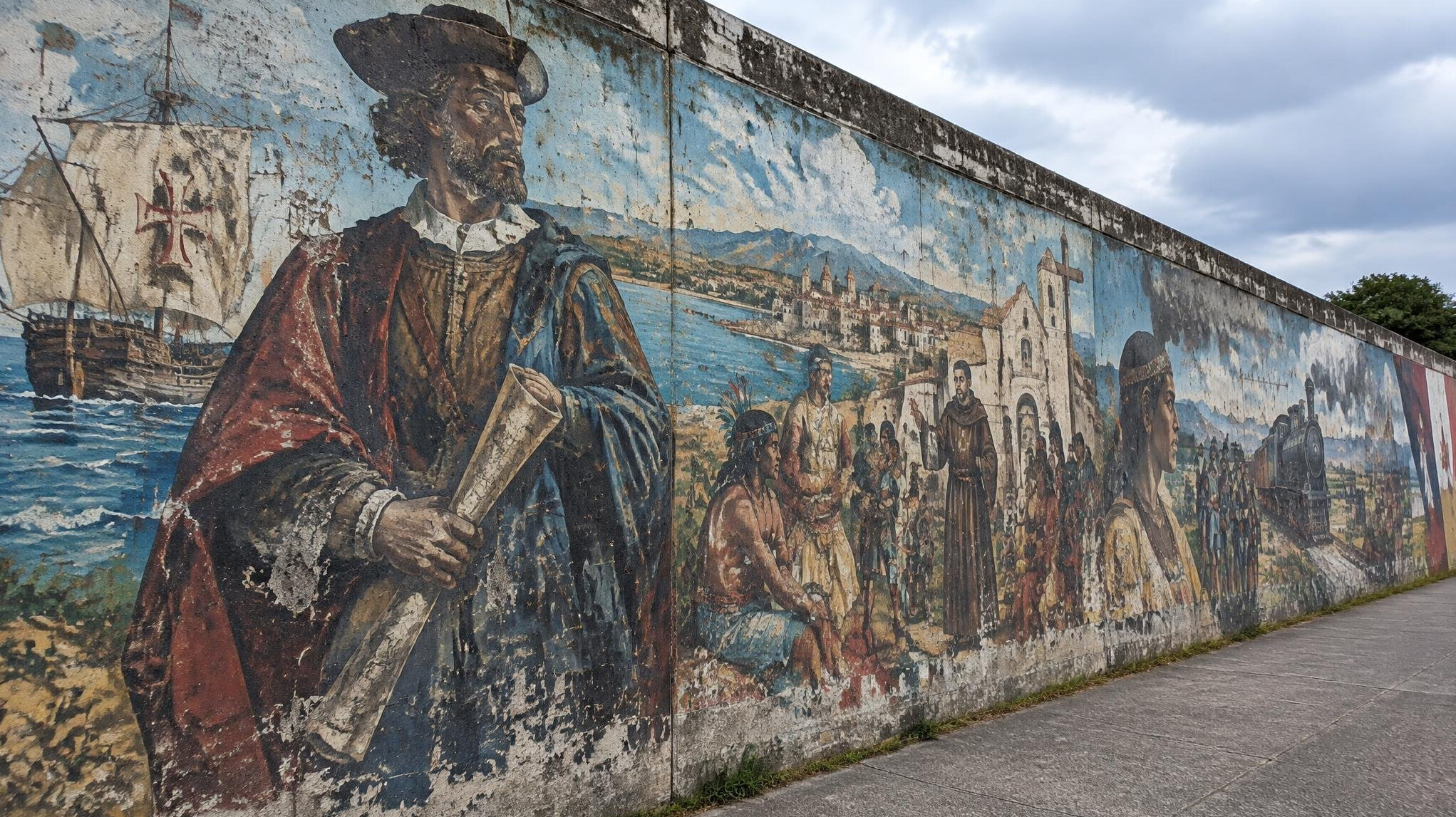 Betonmauer mit farbenfrohem Wandgemälde und historischen Spuren