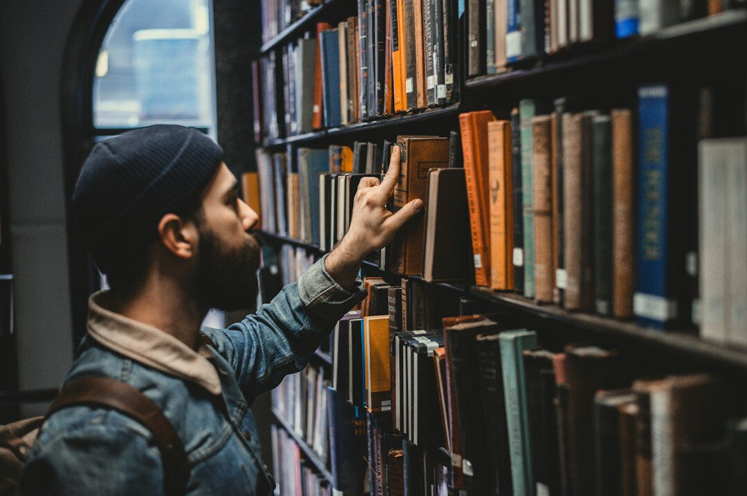 Person betrachtet historische Archivdokumente in einer Bibliothek